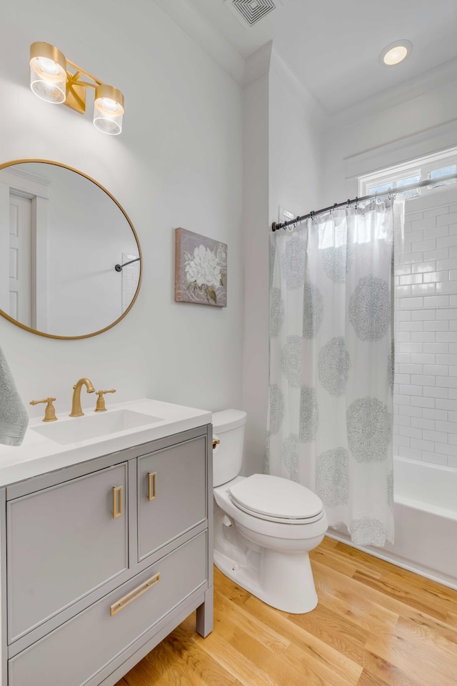 bathroom with toilet, shower / bathtub combination with curtain, wood finished floors, and vanity