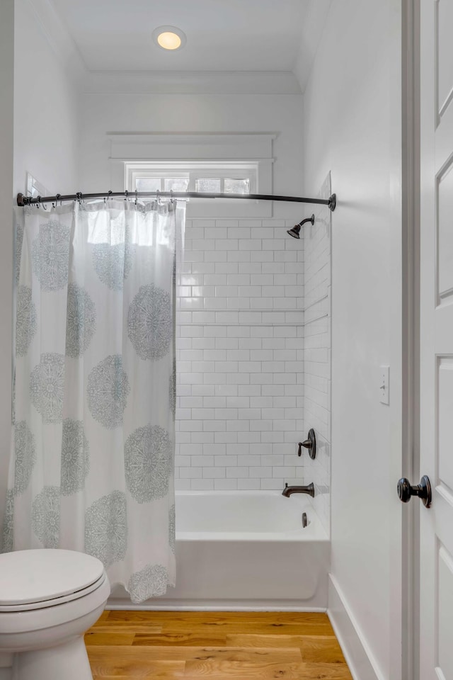 full bathroom featuring toilet, ornamental molding, shower / bath combo, wood finished floors, and baseboards