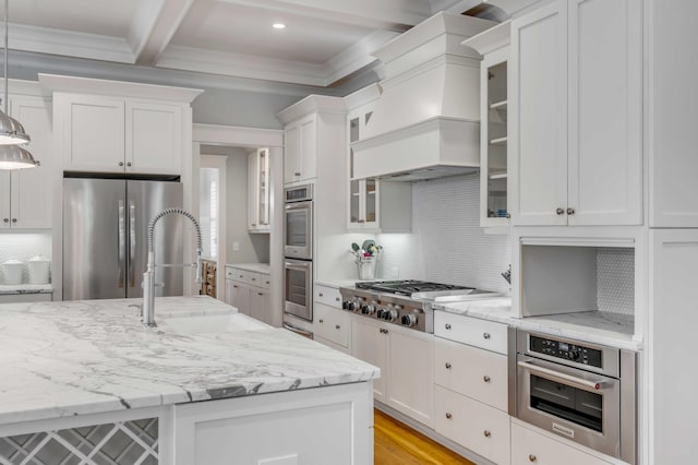 kitchen featuring appliances with stainless steel finishes, white cabinets, beamed ceiling, and light stone counters