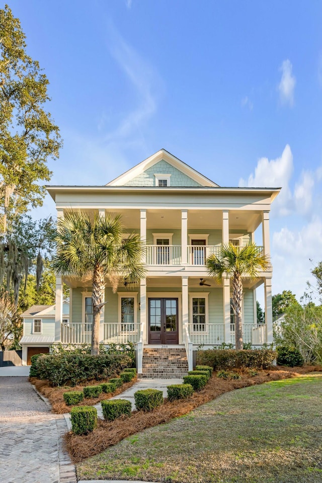 view of front of house with a balcony, covered porch, and french doors