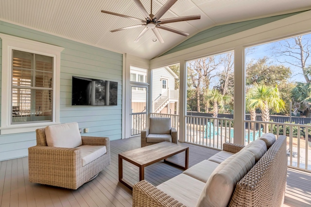 sunroom / solarium featuring a healthy amount of sunlight, vaulted ceiling, and a ceiling fan