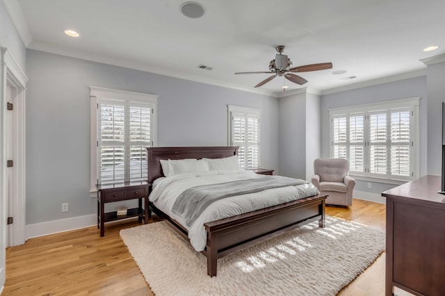 bedroom with light wood-type flooring, baseboards, visible vents, and ornamental molding