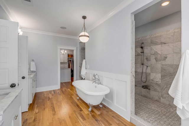 bathroom featuring a soaking tub, walk in shower, crown molding, and vanity