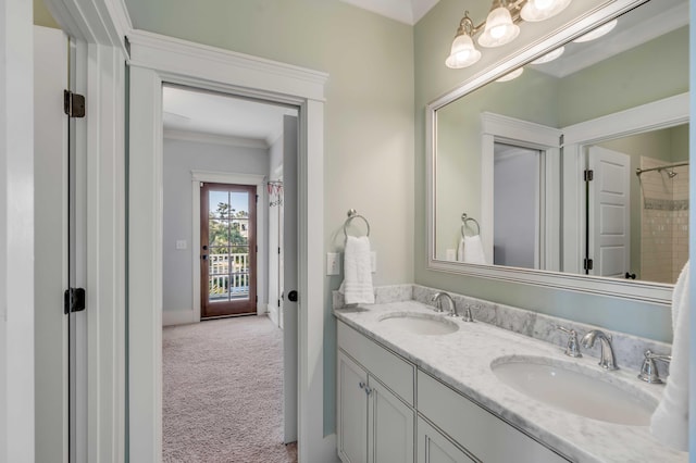 bathroom featuring baseboards, double vanity, a sink, and crown molding