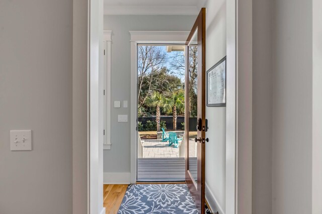 doorway to outside featuring baseboards and wood finished floors