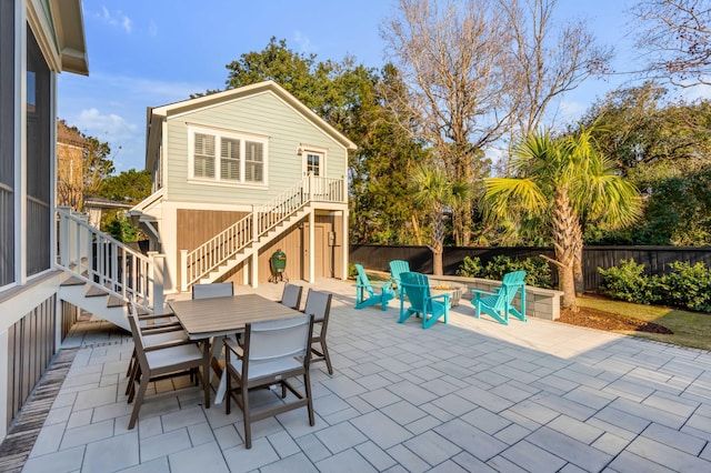 view of patio / terrace featuring outdoor dining area, fence, and stairway