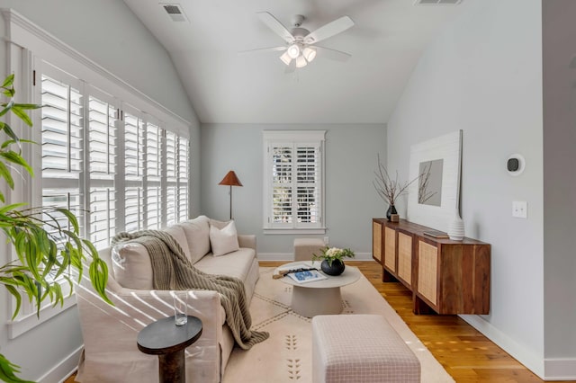 living area with lofted ceiling, ceiling fan, wood finished floors, and visible vents