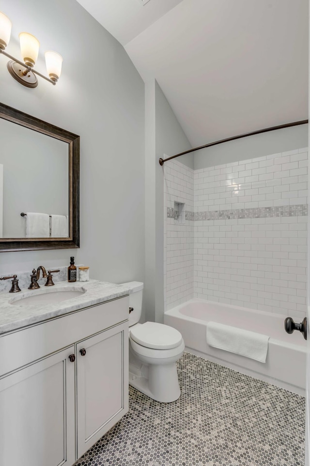 bathroom featuring bathtub / shower combination, toilet, vanity, vaulted ceiling, and tile patterned floors