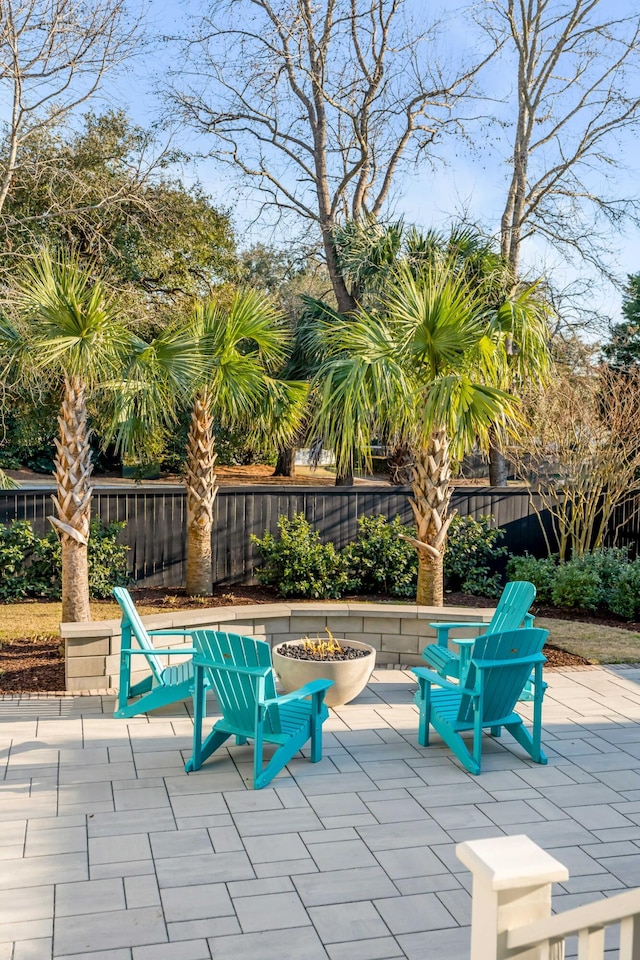 view of patio featuring an outdoor fire pit and fence