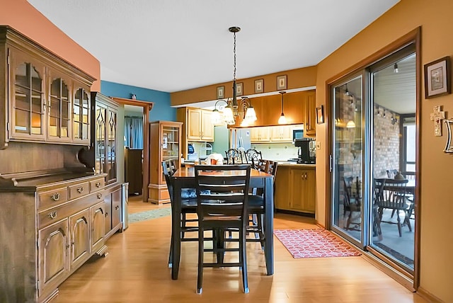 dining space featuring an inviting chandelier and light hardwood / wood-style flooring