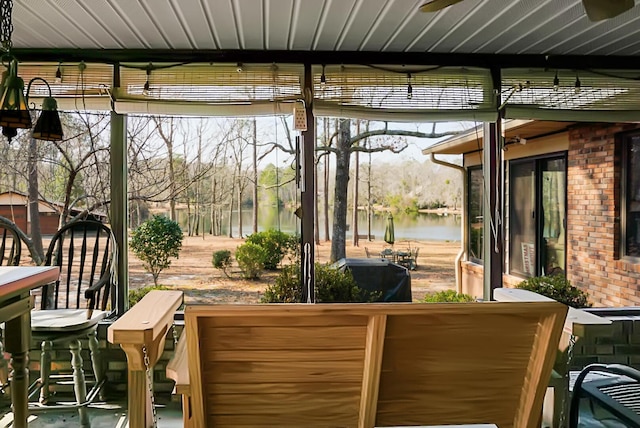 sunroom / solarium featuring a water view