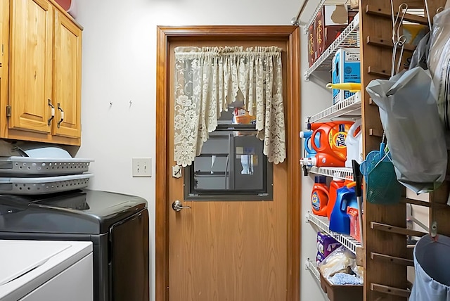 clothes washing area with washing machine and dryer and cabinets