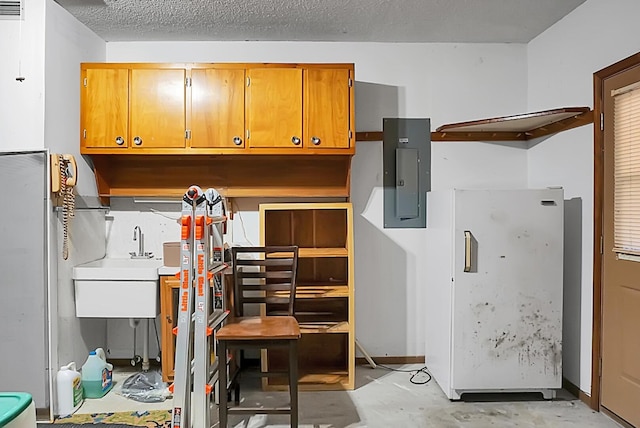 kitchen featuring electric panel, sink, and a textured ceiling