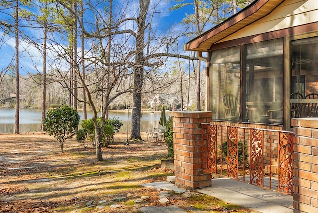 view of yard with a water view and a sunroom