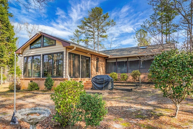 rear view of property featuring a sunroom