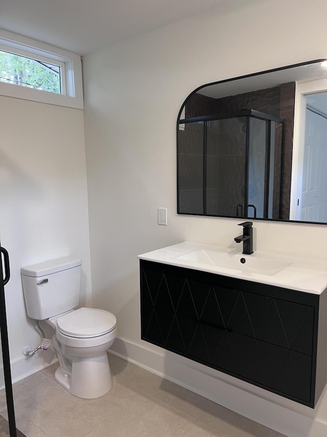 bathroom featuring toilet, a shower stall, tile patterned flooring, baseboards, and vanity