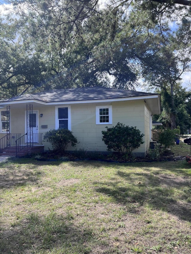 view of side of home with a yard and concrete block siding