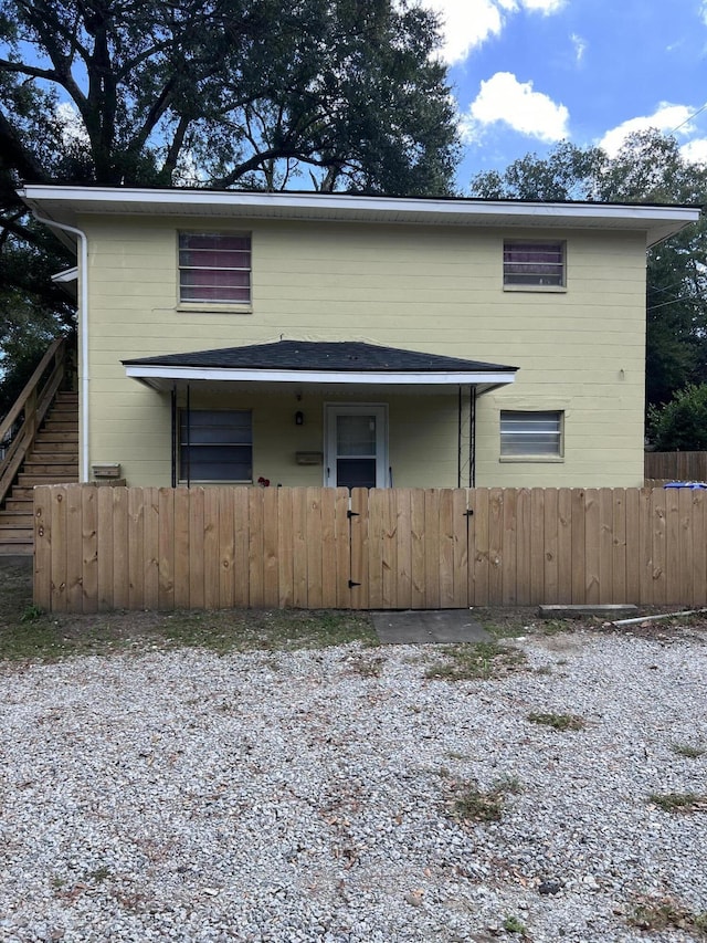 view of front of home with a fenced front yard and stairway