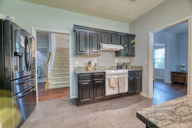 106 Trimley Ct, Goose Creek, SC 29445 - kitchen featuring stainless steel fridge, under cabinet range hood, white range with electric cooktop, light stone countertops, and baseboards