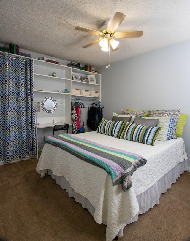 carpeted bedroom with ceiling fan and a textured ceiling