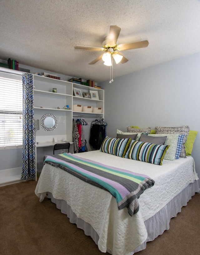 bedroom with ceiling fan, a textured ceiling, and carpet