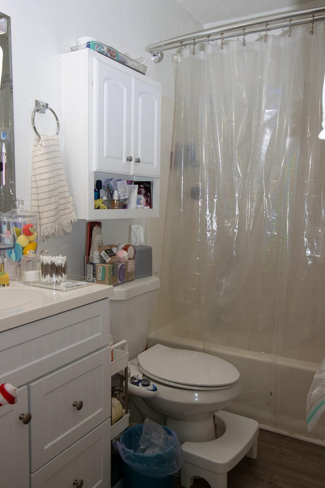 full bathroom with hardwood / wood-style floors, vanity, toilet, and shower / tub combo