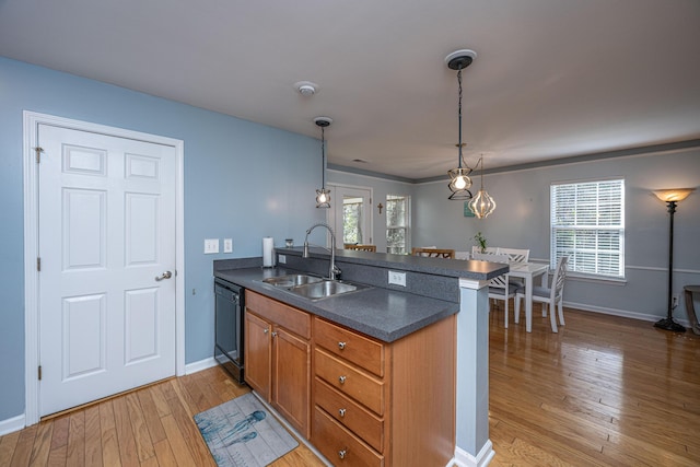 kitchen with hanging light fixtures, kitchen peninsula, sink, and dishwasher