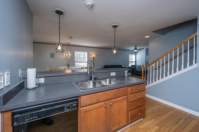 kitchen featuring sink, ceiling fan, hardwood / wood-style floors, hanging light fixtures, and black dishwasher