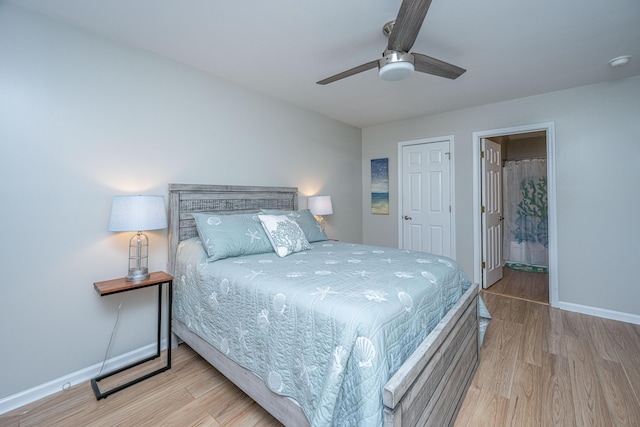 bedroom with ceiling fan, light hardwood / wood-style floors, and ensuite bath