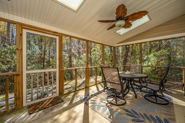 sunroom / solarium with ceiling fan and vaulted ceiling with skylight