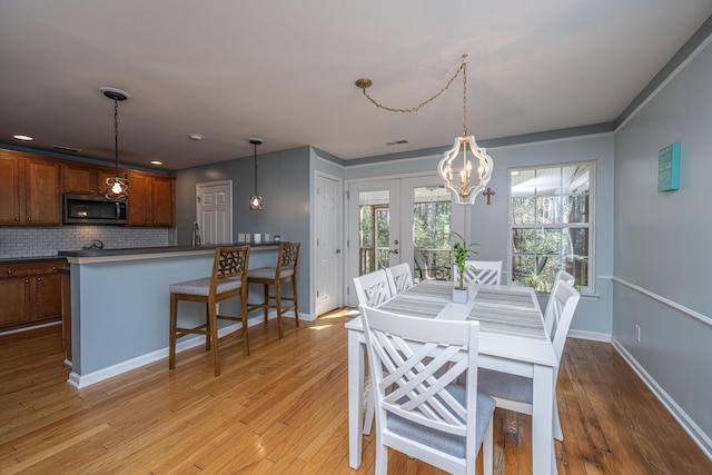 dining space with light wood-type flooring and french doors