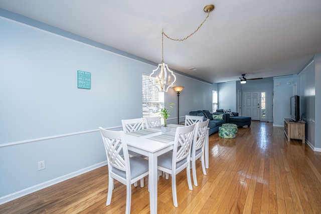 dining area with ceiling fan with notable chandelier and wood-type flooring