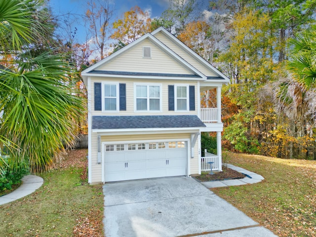 view of front of property featuring a front yard, a balcony, and a garage