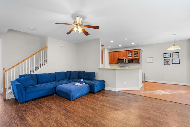 living room with ceiling fan and dark wood-type flooring