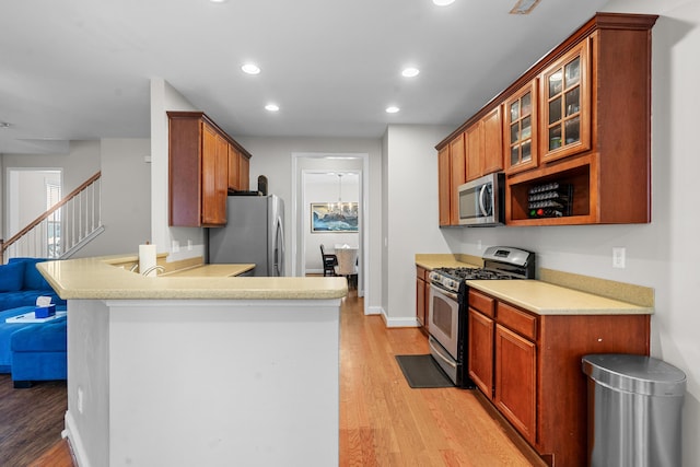 kitchen with kitchen peninsula, light hardwood / wood-style flooring, and appliances with stainless steel finishes