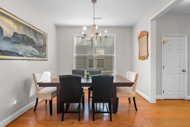 dining room with a chandelier and light wood-type flooring