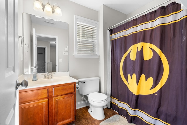 bathroom with hardwood / wood-style floors, vanity, toilet, and curtained shower