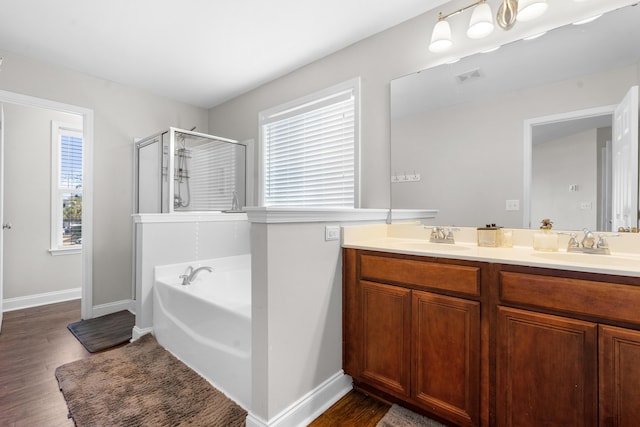 bathroom featuring hardwood / wood-style flooring, vanity, and separate shower and tub