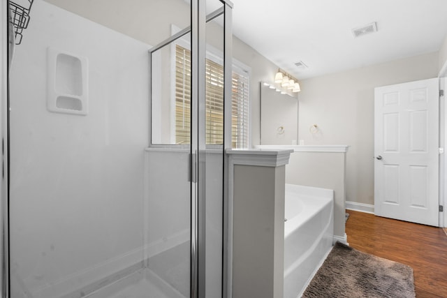 bathroom featuring hardwood / wood-style floors and shower with separate bathtub