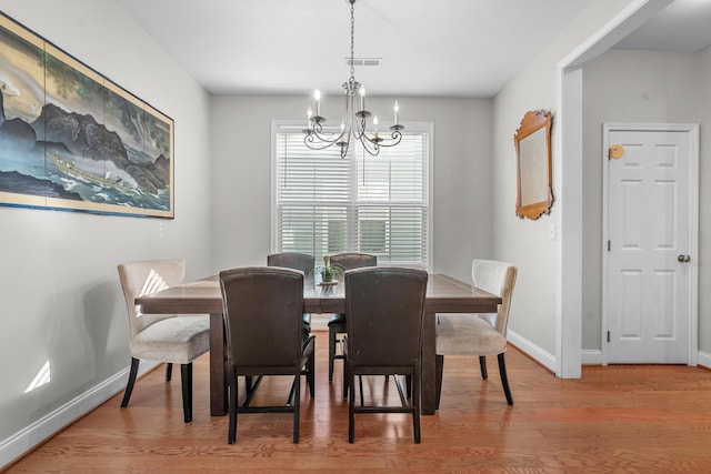 dining room with hardwood / wood-style floors and a chandelier