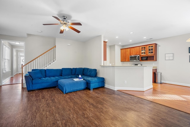 living room featuring ceiling fan and dark wood-type flooring