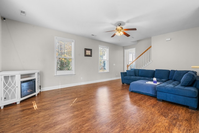 living room featuring ceiling fan and dark hardwood / wood-style flooring