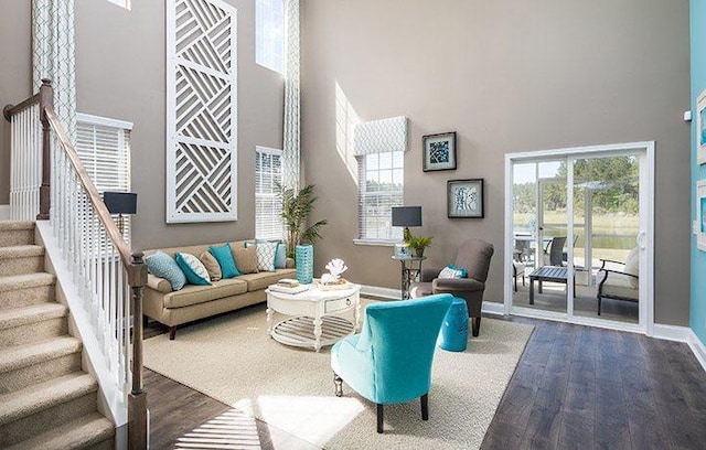 living room featuring hardwood / wood-style flooring and a towering ceiling