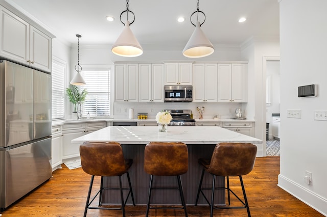 4009 E Amy Ln, Johns Island, SC 29455 - kitchen with stainless steel appliances, ornamental molding, decorative backsplash, a center island, and a kitchen bar