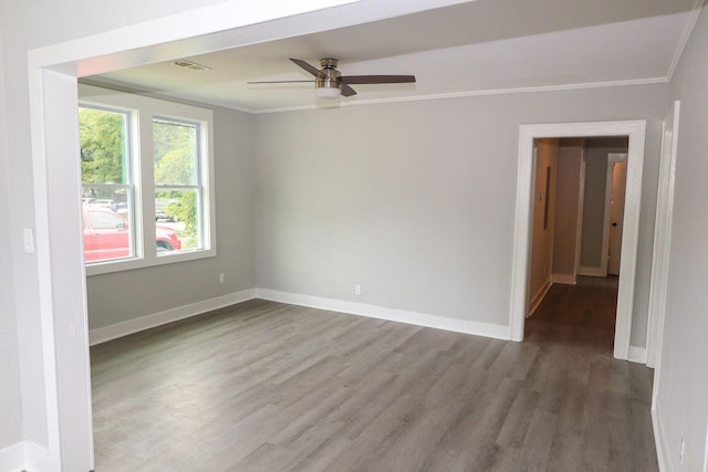 unfurnished room with baseboards, visible vents, a ceiling fan, wood finished floors, and crown molding