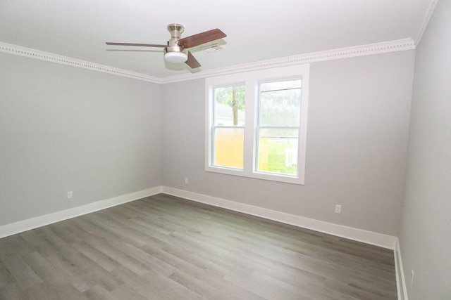 unfurnished room with ceiling fan, crown molding, baseboards, and wood finished floors