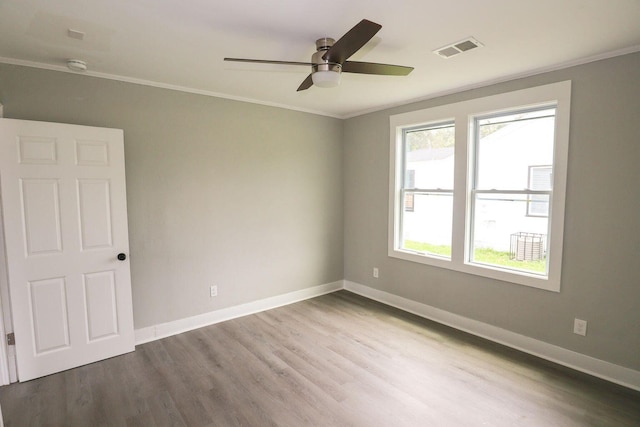 unfurnished room with visible vents, crown molding, and baseboards