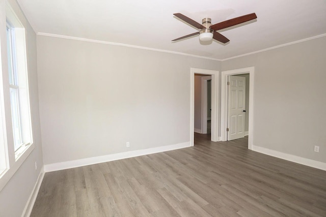 unfurnished room with baseboards, wood finished floors, and crown molding