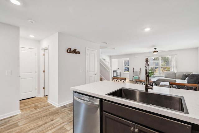 kitchen with dishwasher, open floor plan, light countertops, light wood-type flooring, and a sink