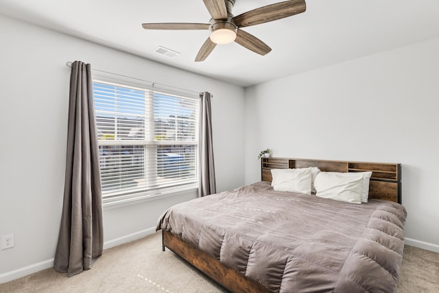 bedroom featuring baseboards, ceiling fan, visible vents, and light colored carpet